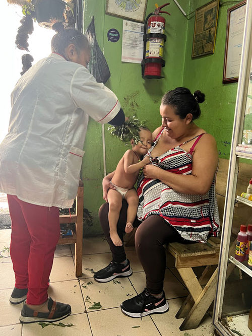 A woman brought her baby to a curandera in Quito for a traditional herbal cleansing.