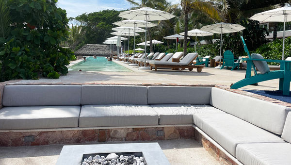The adults-only pool area at the W Punta de Mita features a glass pool wall and a fire pit.