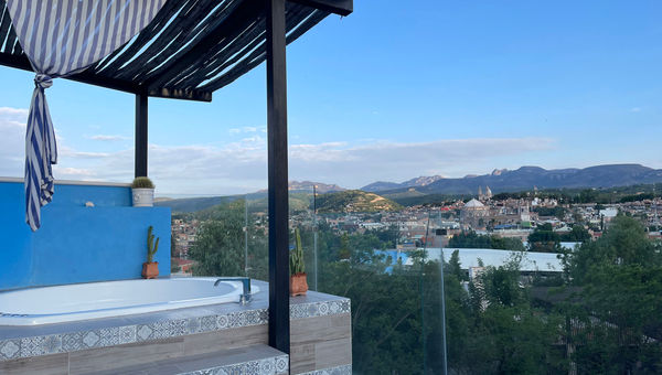 The rooftop spa pool at Casa Bugambilias offers views of the city and the mountains in the distance.