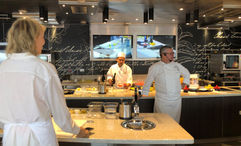 Chef John Stephano wears a headset in the Culinary Arts Kitchen aboard Seven Seas Grandeur so his comments are easily heard by all 18 students.